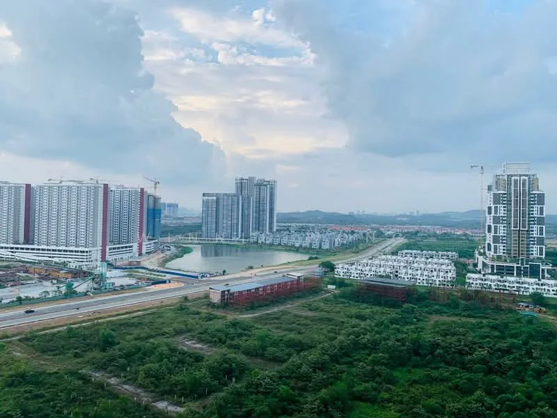 Exterior type: high-rise condominium; features: multiple high-rise buildings, waterfront view, surrounding greenery, construction cranes visible, urban landscape, roadway in foreground, mixed-use development, city skyline in background; style: modern.