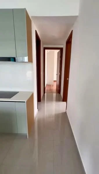 Kitchen features: green cabinetry, white countertop, stainless-steel sink, built-in stove, glossy finish, tile backsplash, open layout, modern design; style: modern. Hallway features: glossy tile flooring, white painted walls, wooden doors, natural light from openings, neutral color scheme; style: modern.