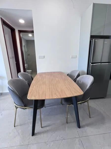 Dining features: wooden dining table, 4 upholstered dining chairs, grey fabric upholstery on chairs, gold metal legs on chairs, light grey cabinetry in background, stainless-steel fridge visible, white walls, tile flooring; style: modern.