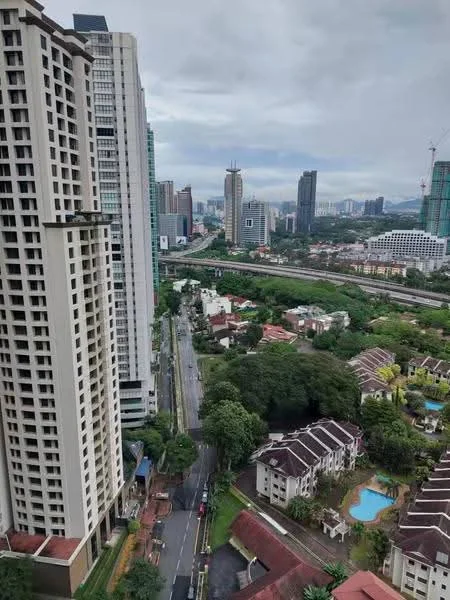 Exterior type: high-rise condominium; features: city skyline view, surrounded by greenery, near main road, multiple high-rise buildings, low-rise residential buildings, swimming pools visible in residential area, well-maintained roads, urban landscape; style: modern.