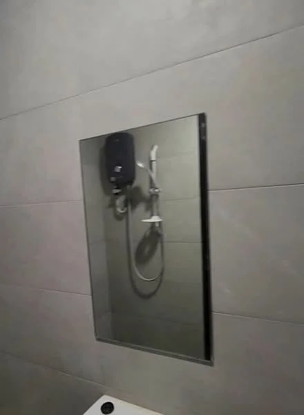 Bathroom features: grey tile walls, mirror, shower with handheld shower head, wall-mounted shower mixer, shower wall with tile cladding, white bathtub, chrome faucet, soap dispenser; style: modern.