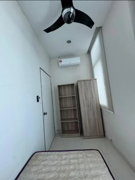 Room features: white painted walls, tile flooring, 5-blade ceiling fan, wall-mounted split AC, single door, wooden storage cabinet, window with sheer curtains, mattress on the floor.