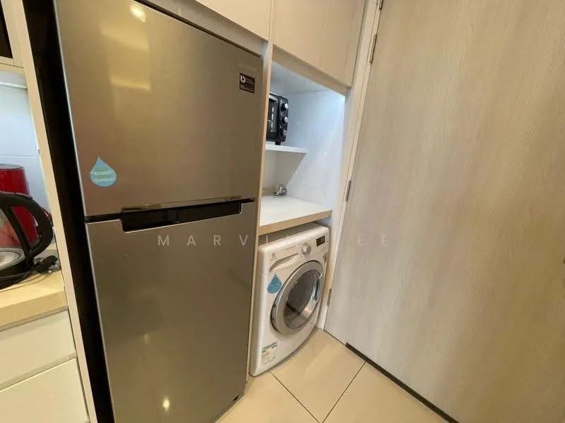 Laundry features: stainless-steel fridge, front-load washing machine, white cabinetry, light-colored countertop, neutral tile flooring, built-in shelving, microwave, door leading to hallway; style: modern.