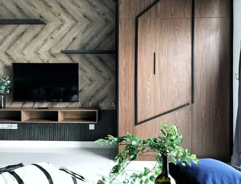 Living features: chevron-patterned wood accent wall, built-in wooden cabinetry, wall-mounted TV, black floating shelves, light-colored flooring, decorative plant in ceramic pot, sliding wardrobe with geometric design, black trim on cabinetry; style: modern.