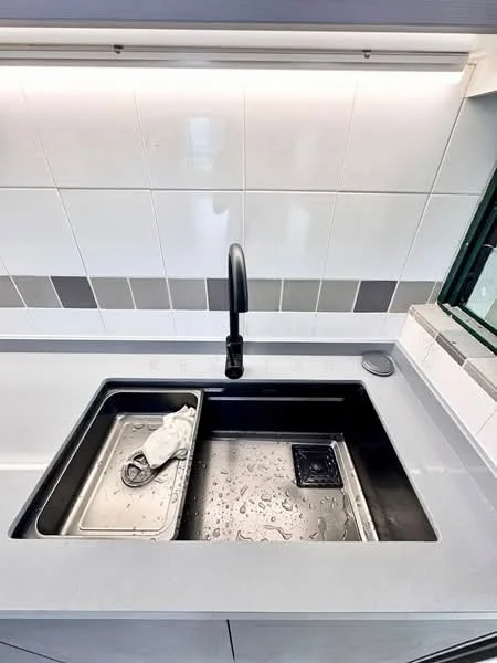 Kitchen features: double-bowl stainless-steel sink, matte-black gooseneck faucet, grey countertop, white tiled backsplash with grey accents, built-in soap dispenser, drainage tray, water droplets on sink, modern cabinetry; style: modern.