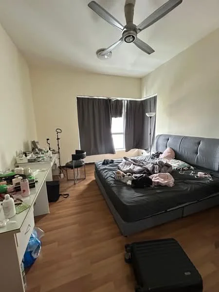Bedroom features: queen-size bed, upholstered headboard, 5-blade ceiling fan, wooden flooring, floor-to-ceiling window, blackout curtains, dressing table, lamp, messy bedding, suitcase on floor, various personal items on dresser.