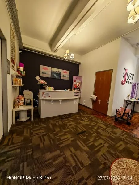 Room features: reception desk, dark accent wall, light-colored walls, wooden door, ceiling lights, carpet flooring, shelving unit, decorative wall art, coffee machine, storage cabinets, children's stroller; style: modern.