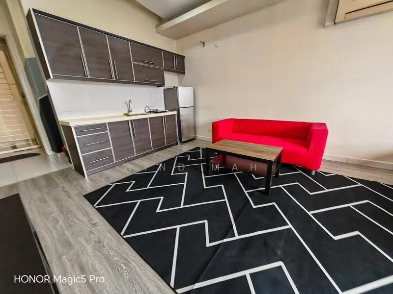 Living features: red fabric sofa, coffee table, black area rug with geometric pattern, kitchenette with dark wood cabinetry, stainless-steel fridge, single-bowl stainless-steel sink, chrome pull-down faucet, white countertop, wall-mounted air conditioning unit, light-colored walls, laminate flooring; style: modern.