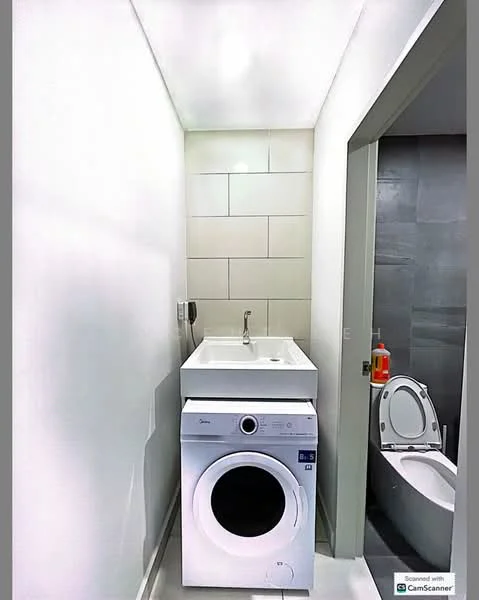 Laundry features: white front-load washing machine, white tumble dryer, single-bowl stainless-steel sink, grey tiled walls, white painted walls, modern faucet, floor-mounted toilet, light grey flooring, recessed ceiling lights; style: modern.