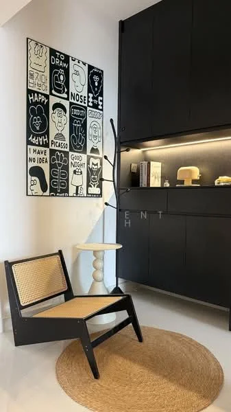 Room features: black cabinetry, white walls, artwork with black and white illustrations, wooden chair with cane seat, round side table, jute area rug, decorative plant stand, minimalist decor; style: modern.