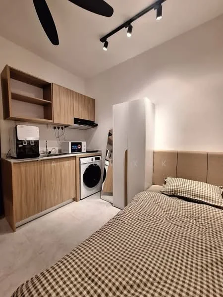 Room features: queen-size bed with beige upholstered headboard, checkered bedding in brown and white, wooden cabinetry in light oak finish, white refrigerator, front-load washing machine, microwave, coffee machine, mirror, ceiling fan with black blades, recessed LED downlights, light-colored tiled flooring, wall-mounted electrical outlets; style: modern.