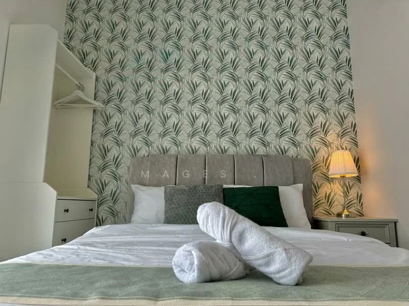 Bedroom features: king-size bed, upholstered headboard, white bedding, green decorative pillow, towels rolled on bed, nightstand, table lamp, built-in wardrobe, floral wallpaper, wooden flooring; style: modern.