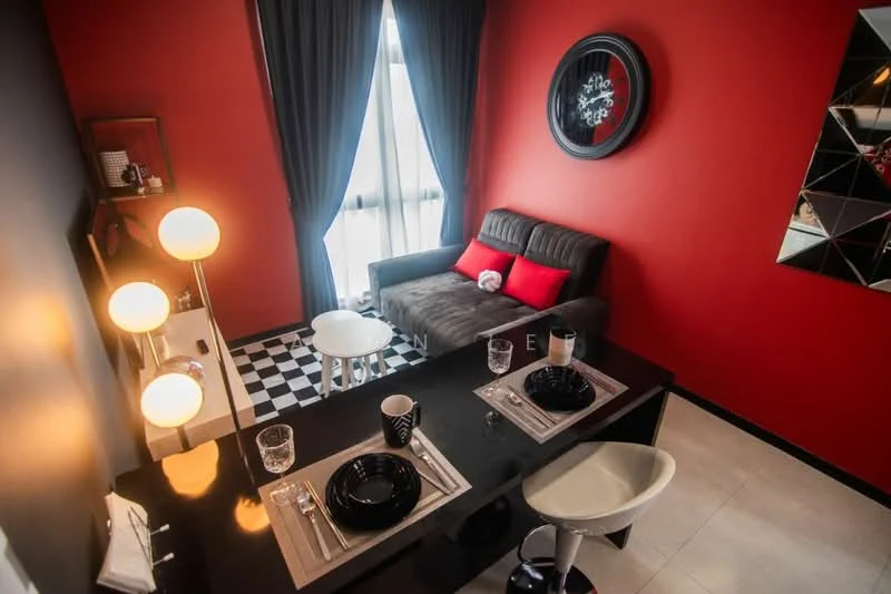 Living features: red accent wall, grey fabric sofa, black and white checkered flooring, white round coffee table, black dining table, black dining chairs, two place settings with black plates, floor lamp with three bulbs, large window with sheer curtains, decorative wall clock, mirror with geometric design; style: modern.