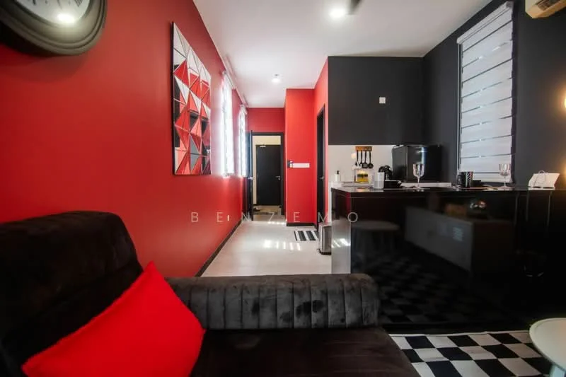 Living features: red accent wall, grey painted walls, black and white checkered flooring, sofa with red cushion, wall-mounted TV, kitchenette with black cabinetry, stainless-steel appliances, window with blinds, decorative artwork on wall, recessed lighting; style: modern.