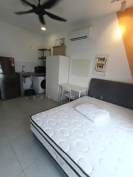 Room features: grey upholstered bed frame, mattress with white bedding, white wall-mounted air conditioning unit, 5-blade ceiling fan, white painted walls, grey tiled flooring, stainless-steel fridge, white washing machine, white cabinet, wooden shelving unit, small dining table, chair; style: modern.