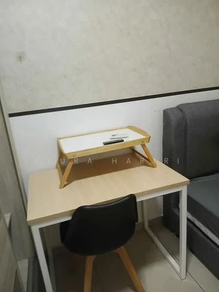 Room features: light wood desk, black chair, white tabletop, grey sofa, light-colored wall, tile flooring, small tray on desk; style: modern.