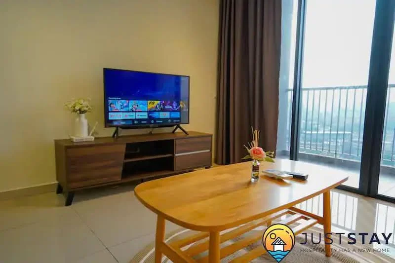 Living features: floor-to-ceiling windows, wooden TV console, wall-mounted TV, coffee table, decorative vase with flowers, area rug, curtains, ceramic tile flooring; style: modern; view: city.