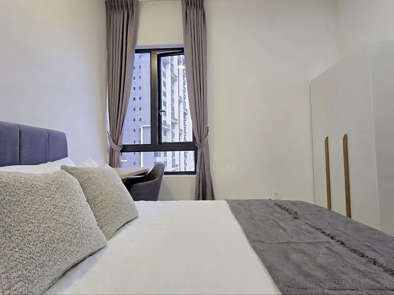 Bedroom features: king-size bed with grey upholstered headboard, white bedding with decorative pillows, grey throw blanket, floor-to-ceiling window, curtains in light grey, built-in wardrobe with white finish, wooden study desk, chair, neutral wall colour, carpet flooring; style: modern; view: city.