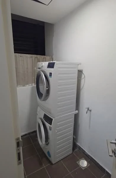 Laundry features: stacked front-load washing machine, stacked dryer, white cabinetry, grey tiled flooring, white painted walls, window with sheer curtains, plumbing connection, drainage outlet; style: modern.