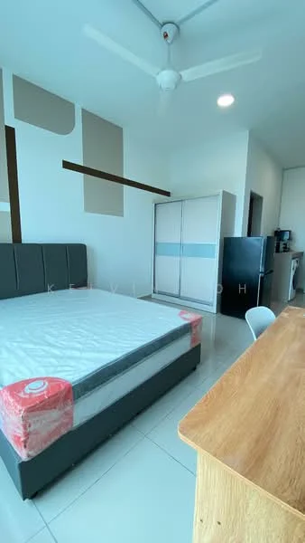 Bedroom features: queen-size bed with mattress, grey upholstered headboard, white walls, ceiling fan, built-in wardrobe with sliding doors, wooden desk, black fridge, kitchenette area with countertop, tile flooring, natural light from window; style: modern.