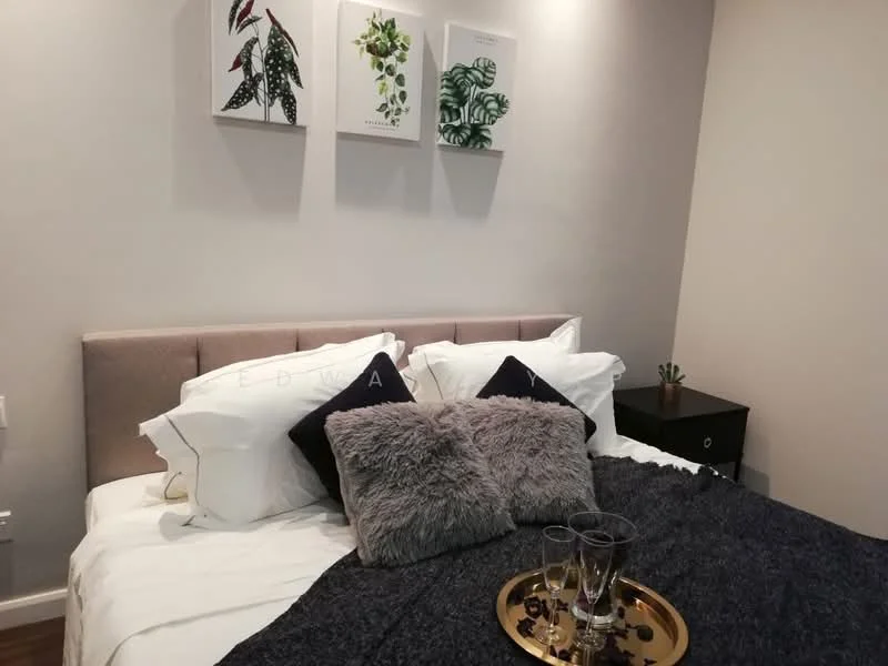 Bedroom features: king-size bed with upholstered headboard, white bedding with decorative pillows, grey throw blanket, nightstand with drawer, decorative plant on nightstand, framed artwork on walls, wooden flooring, soft lighting; style: modern.