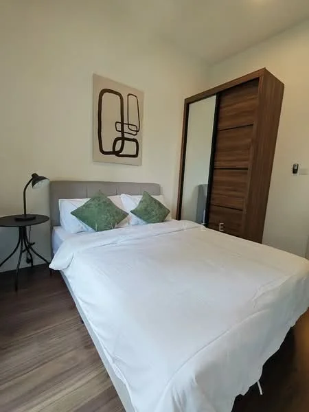 Bedroom features: queen-size bed with white bedding, upholstered headboard, two green decorative pillows, wooden wardrobe with sliding doors, side table with black lamp, framed abstract artwork on wall, wooden flooring, white painted walls; style: modern.