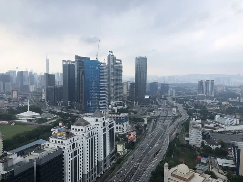 Exterior type: high-rise condominium; features: city skyline view, multiple high-rise buildings, highway visible, green field area, construction crane in view, urban landscape, mixed-use development, modern architectural designs; style: modern.