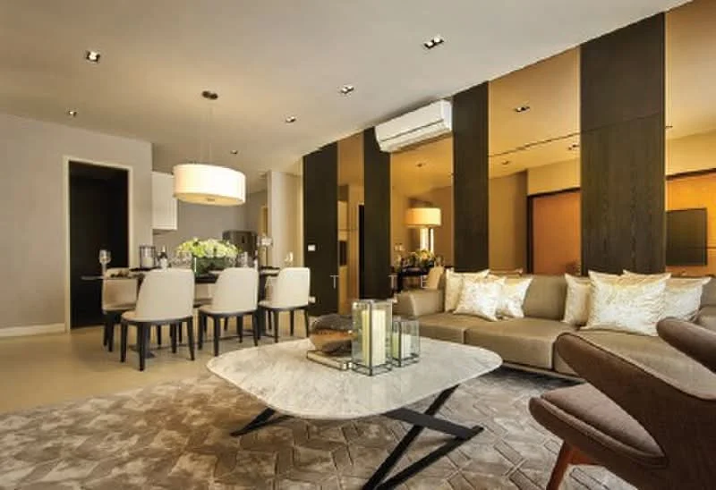 Living features: 3-seater fabric sofa in beige, 2-seater armchair in brown, marble coffee table with black legs, area rug with geometric pattern, recessed LED downlights, wall-mounted TV, built-in cabinetry, floor-to-ceiling windows, air conditioning unit, decorative cushions in gold, dining area with 6-seater dining table, pendant light fixture; style: modern.