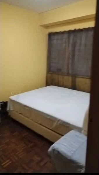 Bedroom features: yellow painted walls, wooden flooring, queen-size bed with no bedding, wooden headboard, curtains on window, single armchair, built-in wardrobe, window with view to outside.