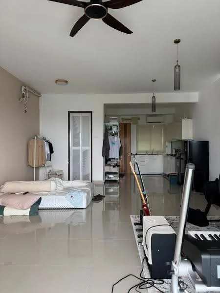 Living features: white painted walls, cream accent wall, polished tile flooring, 5-blade ceiling fan, hanging pendant lights, floor-to-ceiling windows, open layout, clothes rack, mattress on the floor, musical instruments, kitchen area visible in background, utility shelving unit; style: modern.