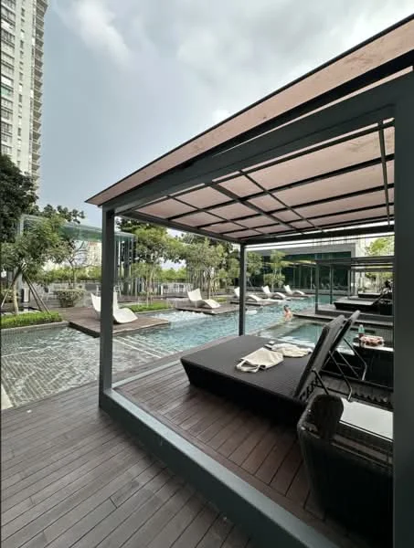 Exterior type: swimming pool deck; features: infinity pool, pool deck with loungers, covered seating area, wooden decking, landscaped greenery, sun loungers, outdoor dining area, potted plants, modern architecture, glass railing; style: modern.