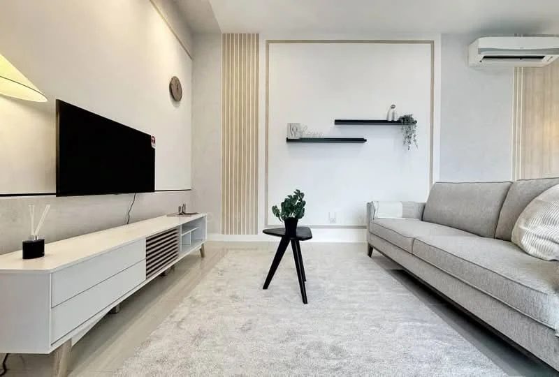Living features: light grey fabric sofa, black side table, white TV console, wall-mounted TV, recessed wall shelves, decorative plant on table, cream area rug, white painted walls, air conditioning unit, wood accent wall; style: modern.