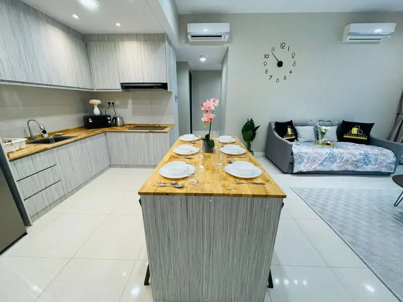 Kitchen features: light wood cabinetry, stainless-steel sink, chrome pull-down faucet, wood countertop, built-in oven, stainless-steel fridge, ceramic tile flooring, recessed downlights, 2 wall-mounted split ACs, island with seating, decorative flower arrangement; style: modern. Living features: grey fabric sofa, decorative cushions, area rug, wall clock, potted plant, recessed downlights; style: modern.