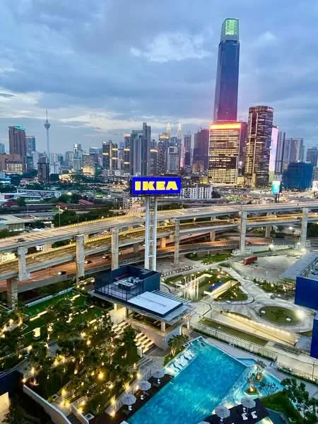Exterior type: high-rise condominium; features: infinity pool, landscape garden, manicured lawn, surrounding city skyline, multi-level roadways, urban amenities, night lighting, adjacent to commercial area; style: modern.
