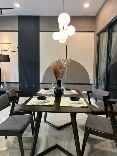 Dining features: modern dining table, 4 dining chairs, decorative vase with dried flowers, black ceramic plates, white table linens, pendant light fixture, grey accent wall, polished tile flooring, large glass windows, minimalist decor; style: modern.