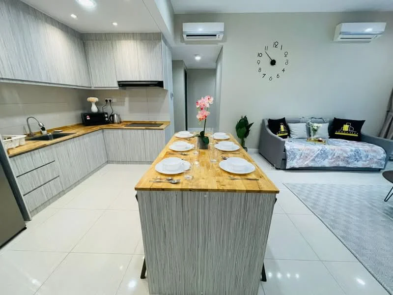Kitchen features: light wood cabinetry, stainless-steel sink, chrome pull-down faucet, granite countertop, kitchen island with seating, built-in oven, stainless-steel fridge, ceramic tile flooring, recessed downlights, wall-mounted split AC, decorative wall clock, grey accent wall; style: modern. Living features: grey fabric sofa, decorative cushions, area rug, wall-mounted split AC, wall-mounted TV, light wood coffee table; style: modern.