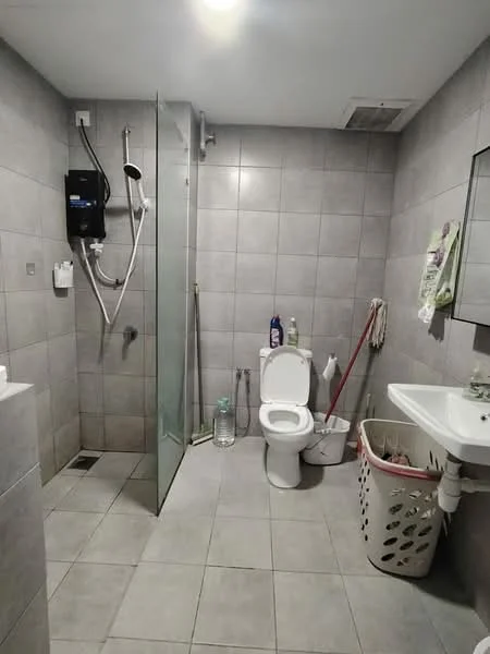 Bathroom features: grey ceramic tile flooring, grey tiled walls, walk-in shower with glass enclosure, chrome shower head, toilet, single-sink vanity with white cabinet, framed mirror, laundry basket, cleaning supplies, water bottles, shower hose, wall-mounted shower control; style: modern.