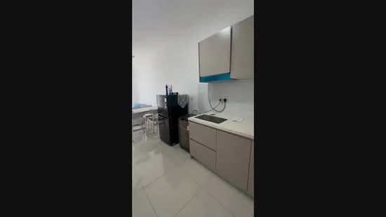 Kitchen features: light grey cabinetry, white countertop, black fridge, built-in cooktop, single-bowl stainless-steel sink, chrome pull-down faucet, ceramic tile flooring, wall-mounted electrical outlets, open shelving, dining table in background; style: modern.