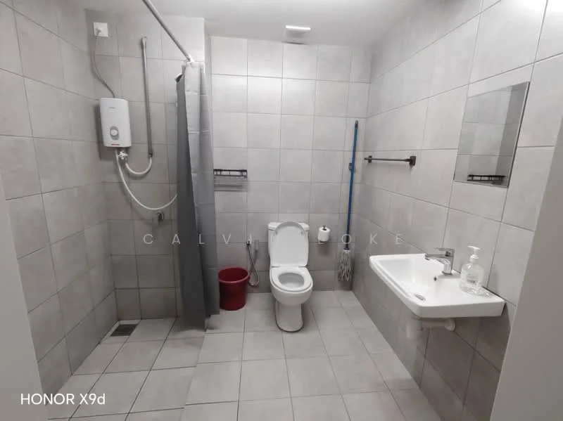 Bathroom features: grey tiled walls, grey tiled flooring, white wall-mounted sink, single basin faucet, toilet, shower area with curtain, water heater, towel rack, toilet paper holder, red waste bin, cleaning supplies holder; style: modern.