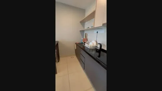 Kitchen features: black granite countertop, light wood cabinetry, built-in sink, single-bowl stainless-steel sink, chrome faucet, ceramic tile flooring, wall-mounted shelves, kitchen appliances visible, neutral wall color; style: modern.