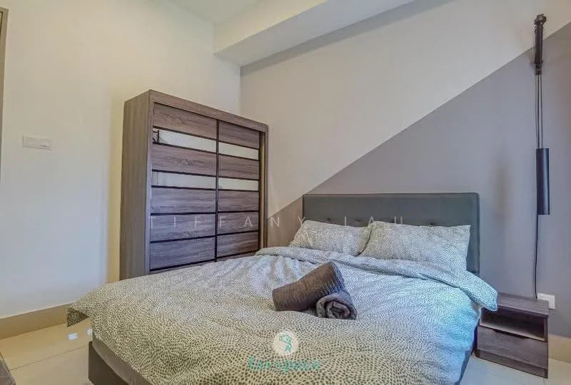 Bedroom features: queen-size bed with patterned bedding, upholstered headboard, wooden wardrobe with sliding doors, grey accent wall, light-colored flooring, decorative throw blanket, bedside wall-mounted lamp, textured throw pillows; style: modern.