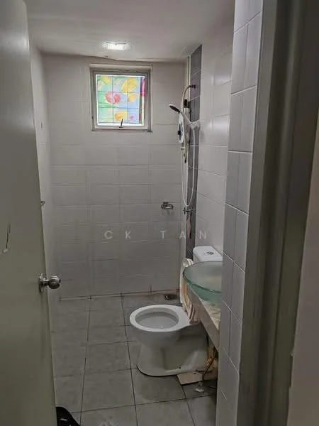 Bathroom features: white tiled walls, grey tiled flooring, toilet, glass basin on countertop, shower with wall-mounted faucet, stained glass window, mirror above basin, light fixture in ceiling.