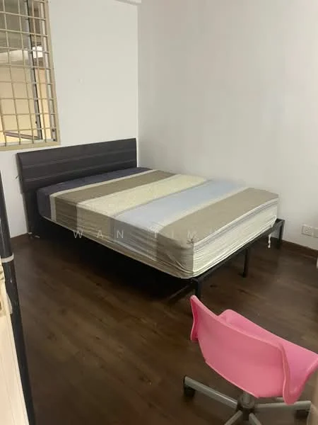 Bedroom features: queen-size bed, wooden bed frame, light brown bedding, wooden flooring, white painted walls, window with metal grille, study chair in pink, desk or table, minimalist decor; style: modern.
