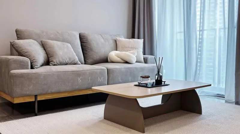 Living features: 3-seater fabric sofa in grey, wooden coffee table with curved design, area rug, floor-to-ceiling windows, sheer curtains, decorative vase with sticks, cushion with text, light grey walls, laminate flooring; style: modern; view: city.