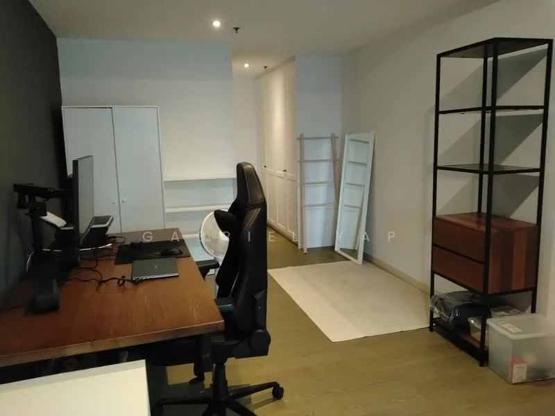 Study features: wooden flooring, grey accent wall, white painted walls, desk with computer monitor, ergonomic office chair, open shelving unit, built-in wardrobe, wooden storage cabinet, white floor mat; style: modern.