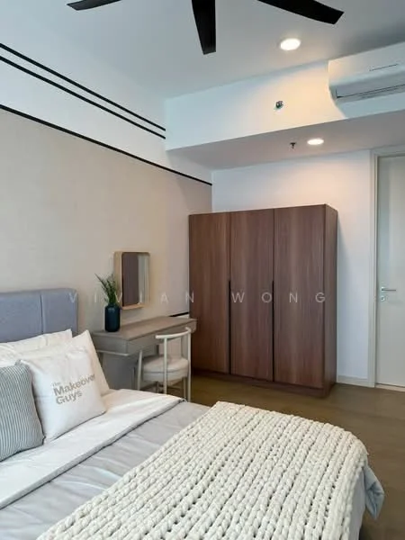 Bedroom features: queen-size bed with grey upholstered headboard, white bedding with textured throw blanket, wooden wardrobe with sliding doors, desk with chair, wall-mounted mirror, ceiling fan, wall-mounted air conditioning unit, light-colored walls, wooden flooring, decorative plant on desk; style: modern.