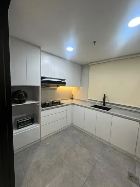 Kitchen features: white cabinetry, grey countertop, single-bowl black sink, chrome pull-down faucet, built-in gas hob, built-in range hood, ceramic tile flooring, recessed LED downlights, window with roller blinds, open shelving, kitchen appliances, neutral wall colour; style: modern.