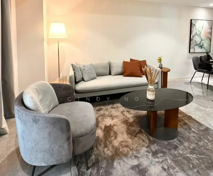 Living features: 3-seater fabric sofa in light grey, accent cushions in various patterns, round coffee table with black top and wooden base, area rug with abstract pattern, floor lamp with white shade, decorative vase with dried flowers, grey upholstered armchair, wall-mounted artwork with abstract design, recessed lighting, light-coloured walls, polished concrete flooring; style: modern.