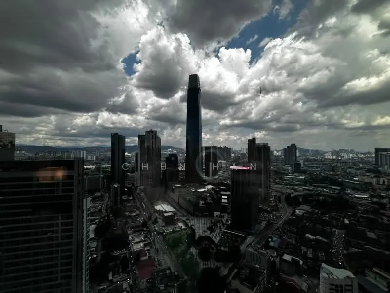 Exterior type: high-rise condominium; features: city skyline view, tall skyscraper, surrounded by urban buildings, cloudy sky, mixed-use development, visible roadways, green spaces in the vicinity; style: modern.