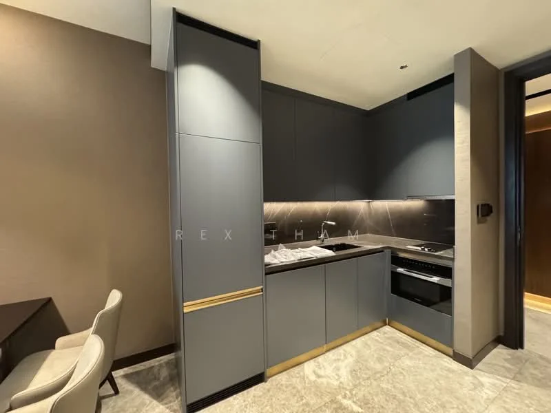 Kitchen features: grey cabinetry with gold handles, black countertop, stainless-steel built-in oven, stainless-steel cooktop, integrated range hood, marble tile backsplash, recessed downlights, grey walls, stone flooring, open shelving, kitchen island, dining area with table and chairs; style: modern.